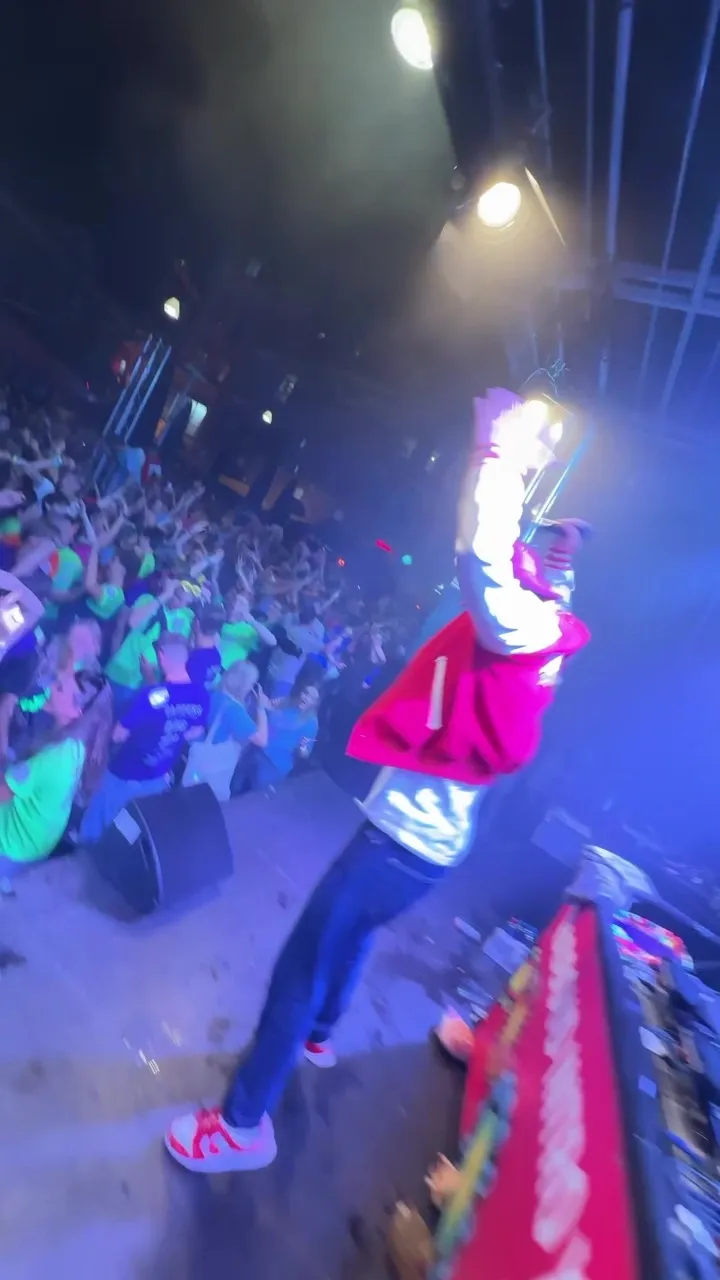 Samuel met zijn arm omhoog op het podium voor een volle zaal bij de intro in Nijmegen